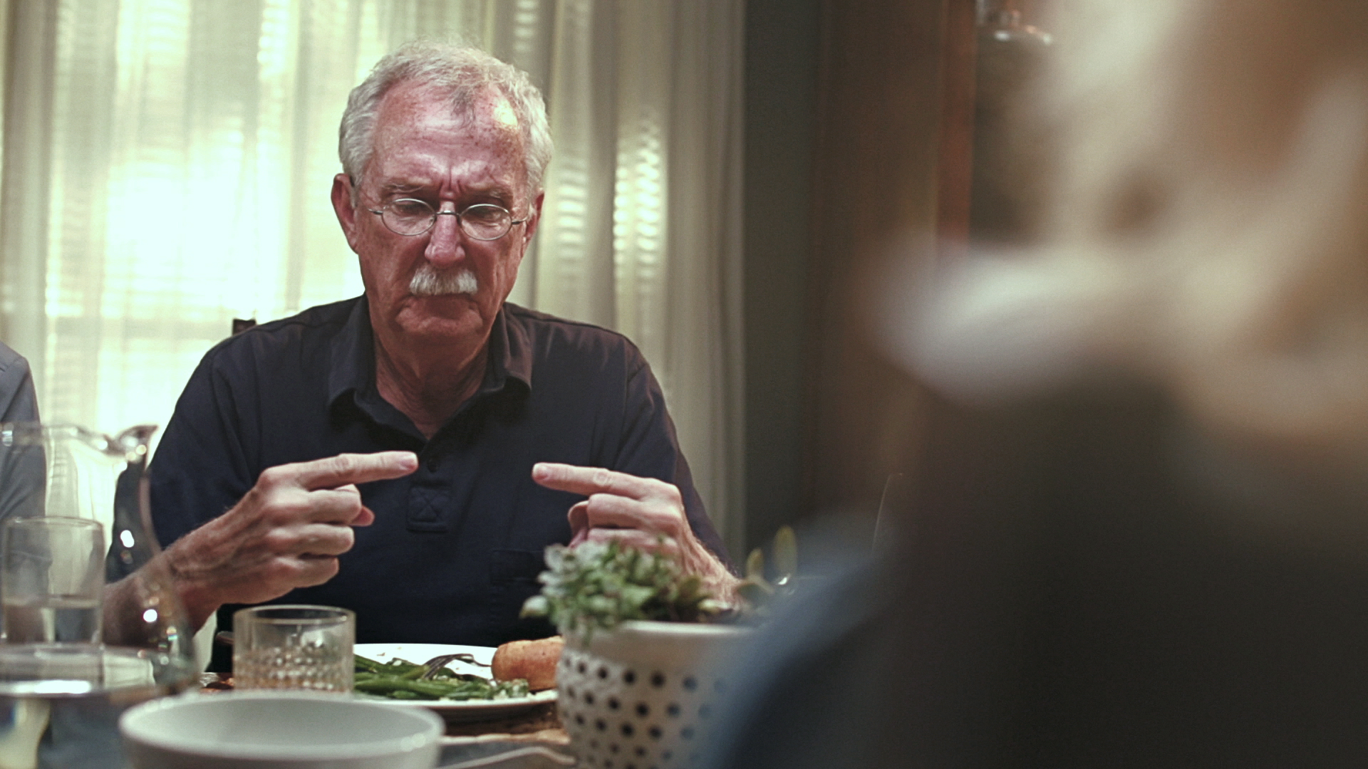 Film still — Bob at the dinner table